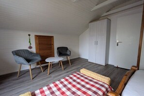 A room with a bed, two chairs, a small table, a wardrobe, and a door. - St. Peter Ording Lütt Witthues (St.Peter-Ording)