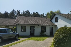 A two-story residential building with a tiled roof, a front door, and a small window on the upper floor. - St. Peter Ording Lütt Witthues (St.Peter-Ording)