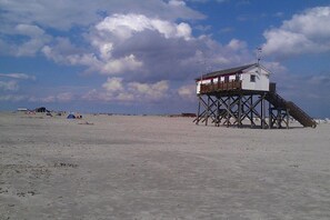 A beach with a wooden structure, possibly a lifeguard tower, and a clear sky. - St. Peter Ording Lütt Witthues (St.Peter-Ording)