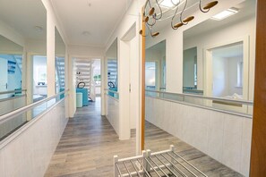 A hotel corridor with a wooden floor, glass railings, and a visible reception area. - Holiday apartment with 2 bedrooms (Sankt Peter-Ording)