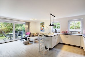 A modern kitchen with a dining area, large windows, and a view of the outdoors. - Holiday apartment with 1 bedroom (Sankt Peter-Ording)
