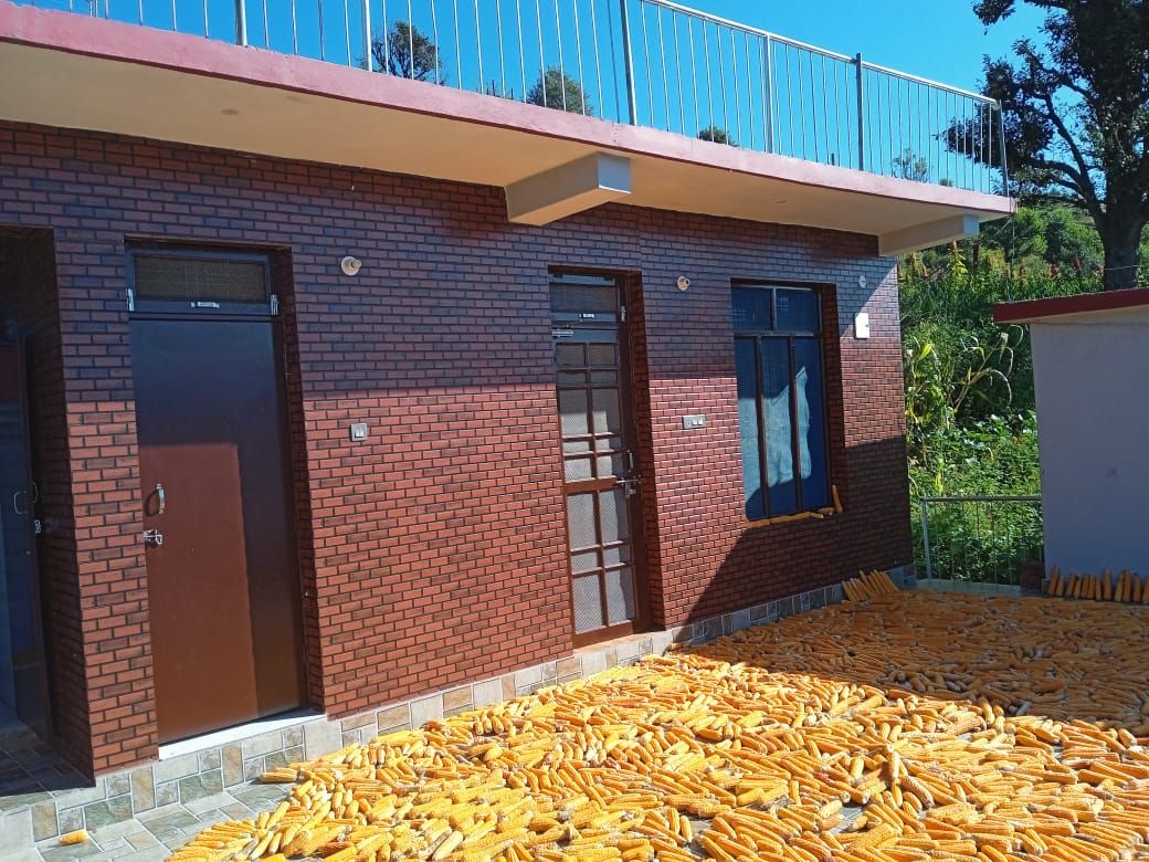 Um edifício com fachada de tijolos vermelhos, telhado plano e varanda.
