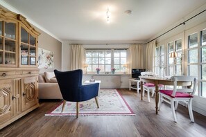 A dining area with a table, chairs, and a cabinet. - Holiday apartment in Sylt with 1 bedroom (Keitum)