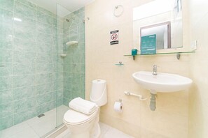 A bathroom with a glass shower enclosure, a toilet, a sink, and a mirror. - Hotel Ayenda Casa Paraiso 1327 (Barranquilla)