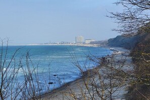 A coastal view with a beach, a clear sky, and buildings in the distance. - Holiday apartment with 2 bedrooms (Bentwisch)