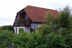 A two-story house with a red-tiled roof and a satellite dish. - Holiday apartment with 2 bedrooms (Bentwisch)