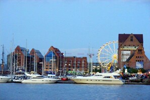 A marina with boats docked, a Ferris wheel, and buildings with signage. - Holiday apartment with 2 bedrooms (Bentwisch)