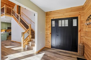 Un interior de madera con una escalera que lleva a una zona de cocina.