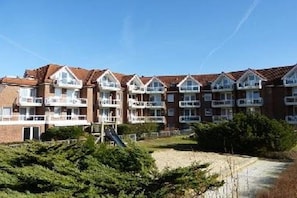 Eine Reihe von Ziegelwohngebäuden mit mehreren Balkonen und blauem Himmel.