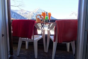 Vista de um quarto com mesa, duas cadeiras, uma garrafa e um copo.