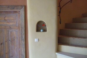 A staircase with a wall-mounted light fixture and a door with a rustic design. - Holiday home in Hitzacker with Wi-Fi (Hitzacker)