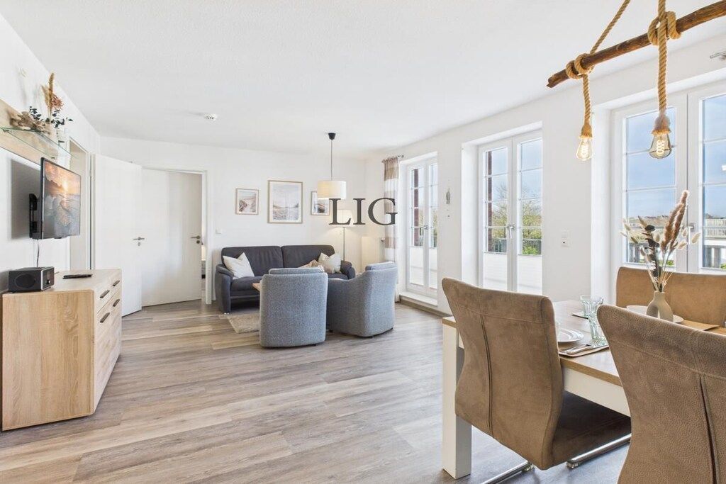 A modern living room with a sofa, ottomans, a dining table with chairs, a TV, and a fireplace.
