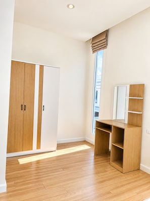 Una habitación con armario, escritorio y ventana.