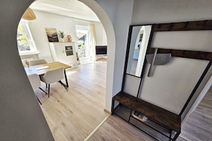 Ein modernes Interieur mit Essbereich, einer eingebauten Bank und Blick durch einen Bogen.