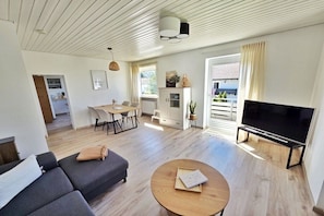 Ett modernt vardagsrum med en soffa, ett soffbord och en tv-apparat med platt skärm.
