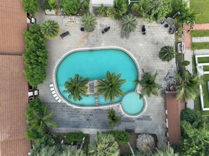 A rooftop pool area with lounge chairs and palm trees. - Spree One Resort and Convention (Shankhavaram)