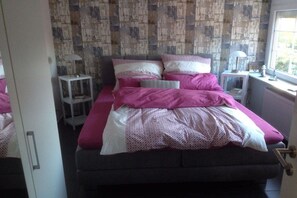 Ein Schlafzimmer mit einem Bett, Nachttischen und einem Fenster.
