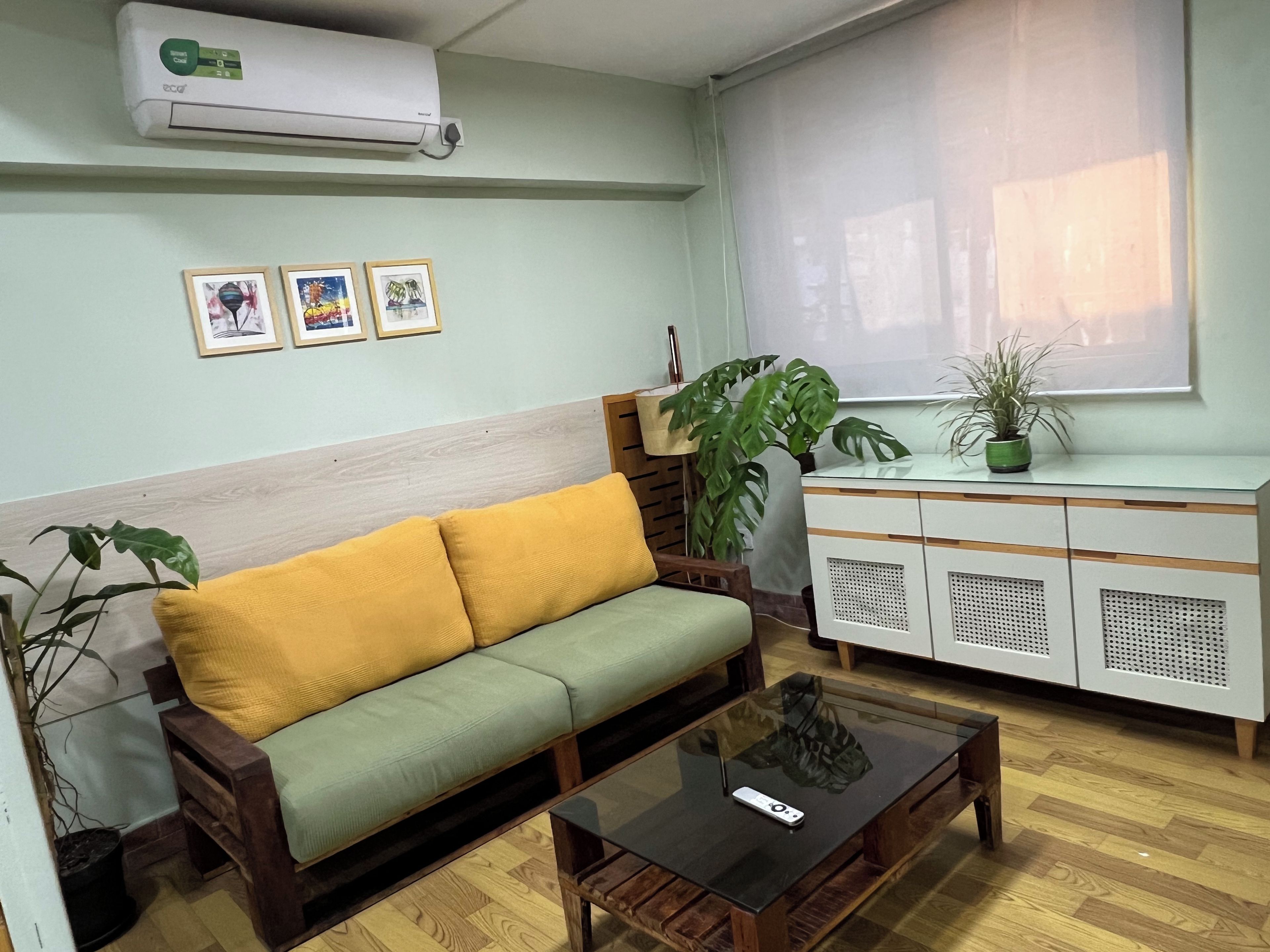 A living room with a sofa, a coffee table, a cabinet, and a large window.