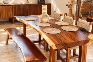A wooden dining table with woven placemats and a bench. - Casa Xulkan: Stunning Jungle Villa with 2 Private Pools (Tulum)