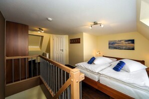 A bedroom with a bed, a wooden railing, a door, and a painting on the wall. - Palace by the Sea, Apt. 7 (Cuxhaven)