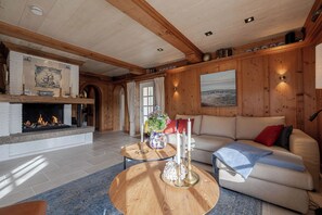 A cozy living room with a fireplace, a sofa, and a coffee table. - Loddis Leev - Kampen (Sylt) (Kampen (Sylt))