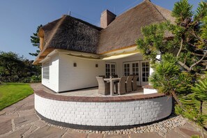 A house with a thatched roof, white exterior walls, and a stone foundation. - Loddis Leev - Kampen (Sylt) (Kampen (Sylt))