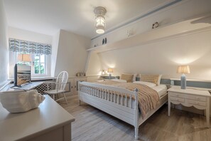 A bedroom with a bed, bedside tables, a chair, a desk, and a window. - Loddis Leev - Kampen (Sylt) (Kampen (Sylt))