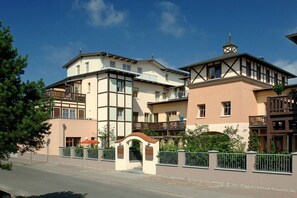 Ein mehrstöckiges Wohngebäude mit Balkonen, einem Innenhof und einem verschlossenen Eingang.
