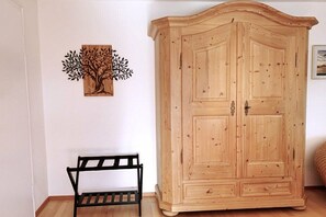 Ein Holzkleiderschrank mit zwei Türen und eine Bank mit Lattenrost.