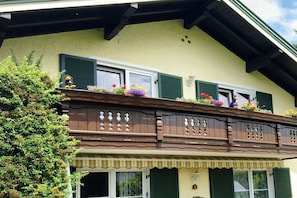 A traditional building with a balcony, green shutters, and flower boxes. - Prestige Apartment Chiemsee (Prien)