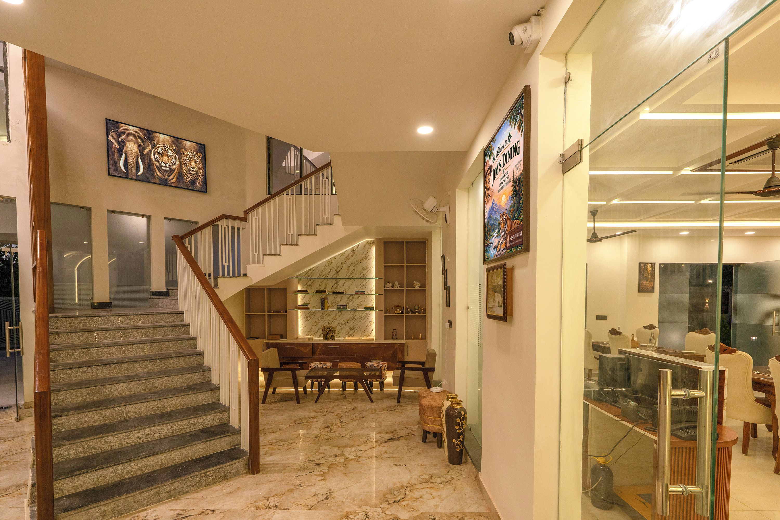 A spacious interior with a marble staircase, a dining area, and a glass-fronted shop.