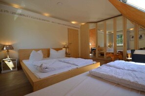 Ein Hotelzimmer mit einem großen Bett, einem Kleiderschrank, einem Schreibtisch und einem Spiegel.
