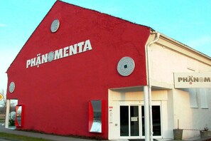 A building with a red facade and the word 'PHÂNOMENTA' on the side. - Holiday apartment with 3 bedrooms (Karlshagen)