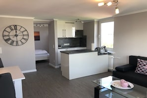 A modern apartment with a kitchenette, a dining area, and a living space. - Holiday apartment with 2 bedrooms (Westerland)