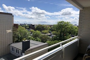 A balcony with a view of a residential area, including houses and parked cars. - Holiday apartment with 2 bedrooms (Westerland)