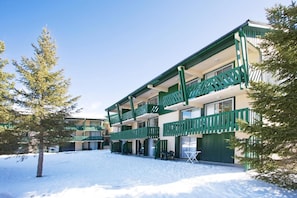 A multi-story building with balconies, a snow-covered ground, and trees. - 100m from ski slopes, parking, ski locker, 17m², Pyrénées 2000 (Pyrénées 2000)