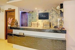 A reception area with a marble counter, a sign indicating 'Office Room,' and a wall-mounted sign with 'Collection' and 'Signature Stay by 010' text. - Collection O SSR Royal Suites (Hyderabad)
