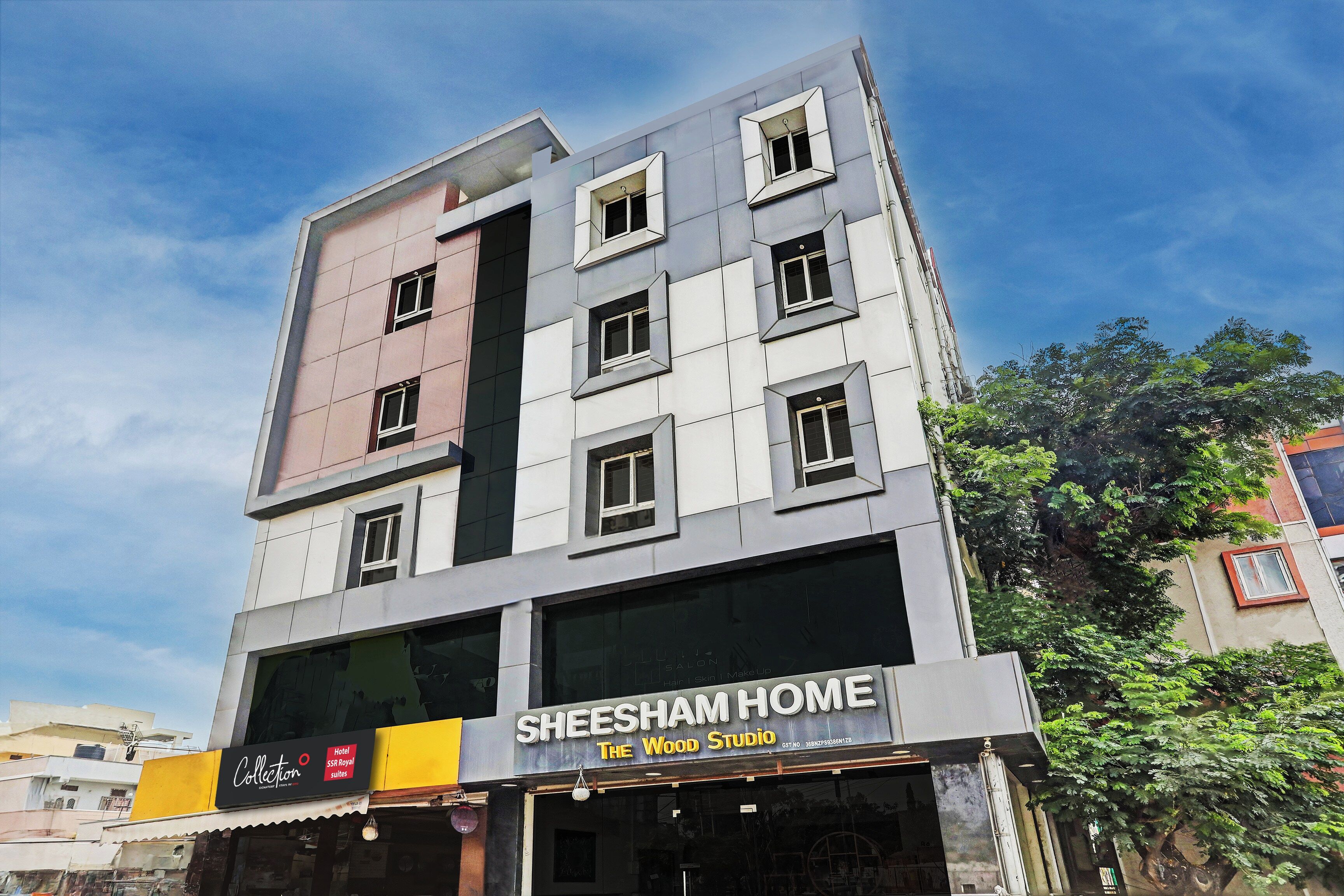 Um edifício com vários andares e uma vitrine com a inscrição 'Sheesham Home The Wood Studio'.
