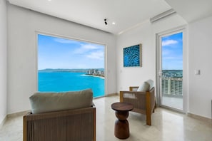 A spacious room with a large balcony, a view of the sea, and a cityscape. - Harbor N2301 by Moikkarentals (Puerto Vallarta)