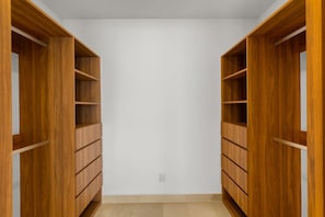 A walk-in closet with wooden shelving and drawers. - Harbor N2301 by Moikkarentals (Puerto Vallarta)