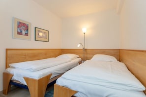 A room with two single beds, a bedside table, a floor lamp, and two framed pictures on the wall. - Holiday apartment Haus Olymp 319676 (Kühlungsborn)
