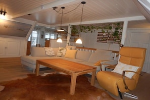 A cozy living room with a sofa, armchair, and wooden coffee table. - Holiday apartment with 2 bedrooms (Wyk OT Boldixum \/ Föhr)