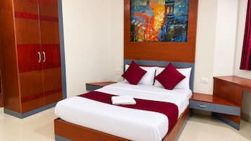 Una habitación de hotel moderna con una cama grande, un armario de madera, una mesita de noche y un cuadro en la pared.
