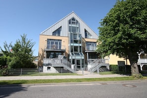 A modern building with a prominent entrance, a staircase leading to the main entrance, and a clear sky above. - Holiday apartment with 2 bedrooms (Kühlungsborn)