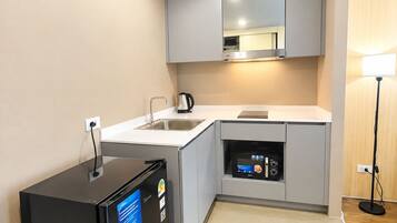 Una cocina moderna con microondas integrado, refrigerador y pileta.