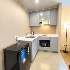 Una cuina moderna amb microones integrat, nevera i rentaplat.