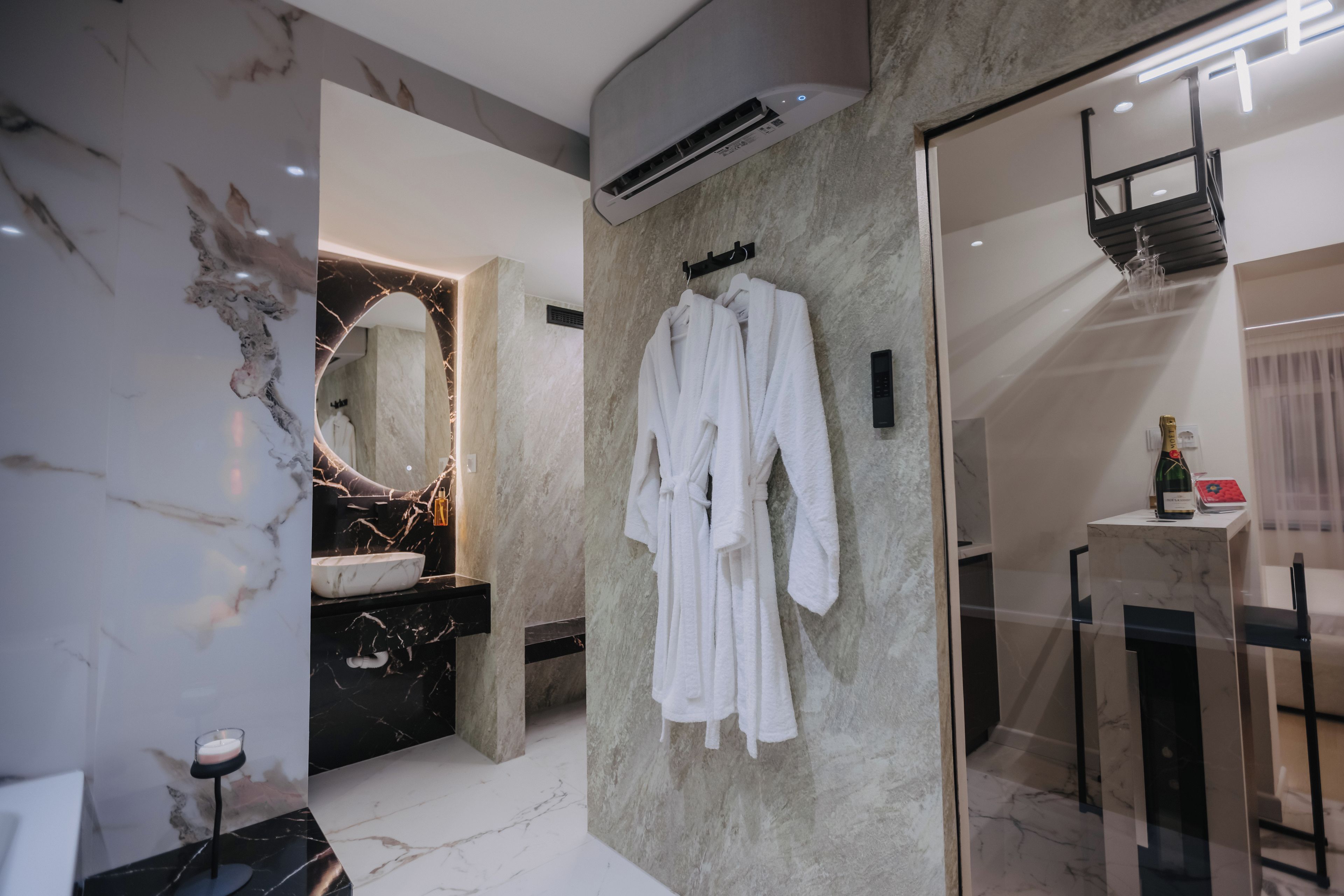 Un baño moderno con tocador de mármol, un espejo grande y cabina de ducha con paredes de vidrio.