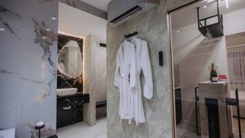 Un baño moderno con tocador de mármol, un espejo grande y cabina de ducha con paredes de vidrio.