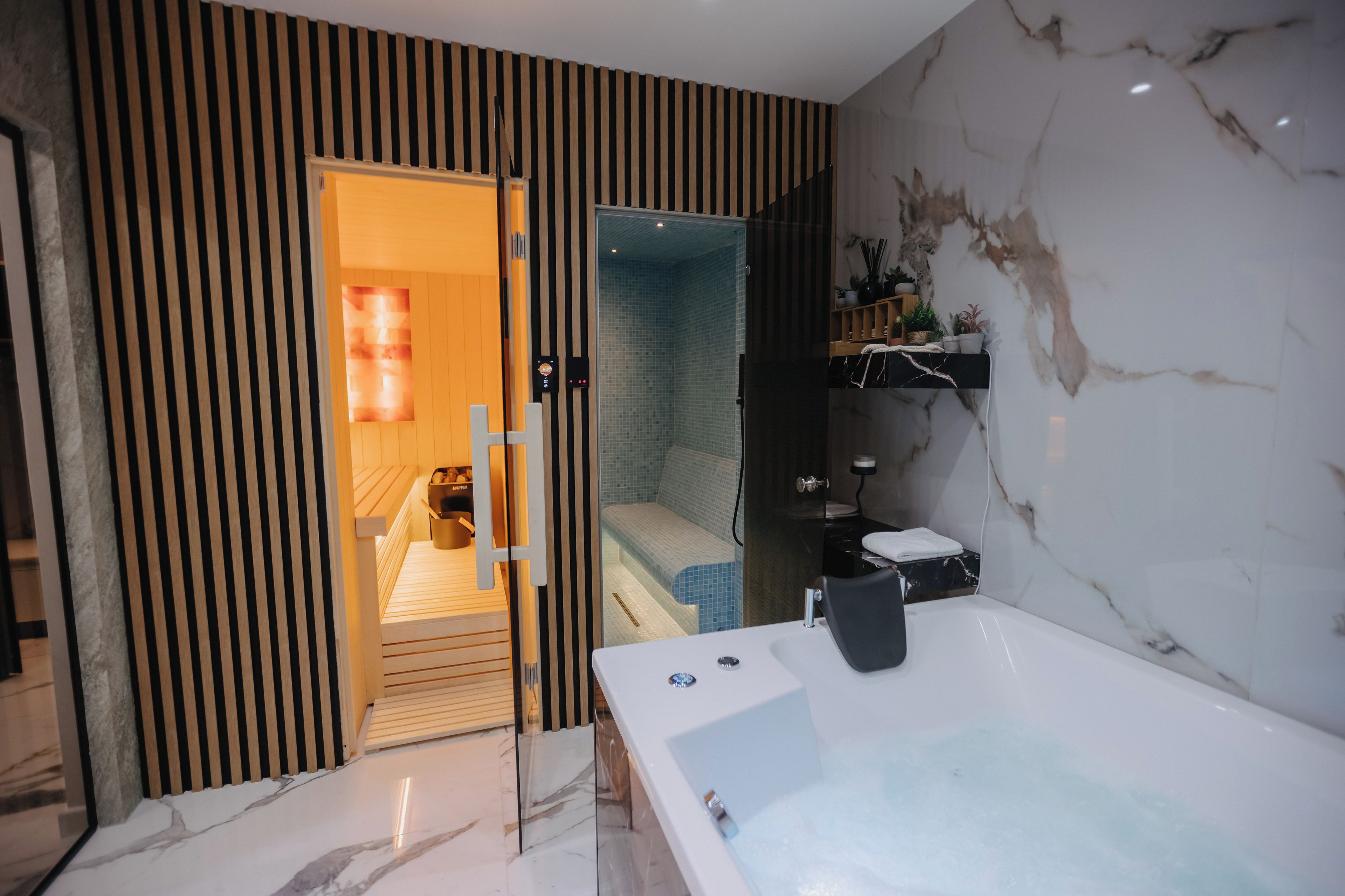 Een moderne badkamer met een ruime badkuip, een douchegedeelte en een wand van hout.