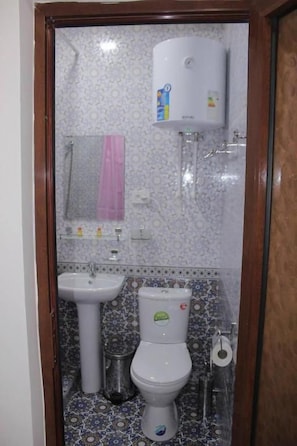 Een badkamer met toilet, wastafel en douche.